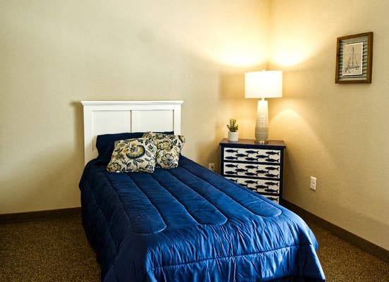 Cozy private resident room with a single bed and lamp