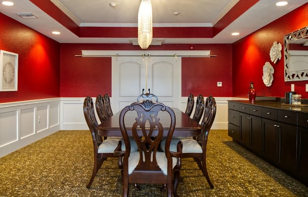 Elegant dining room with a long table and red accent walls