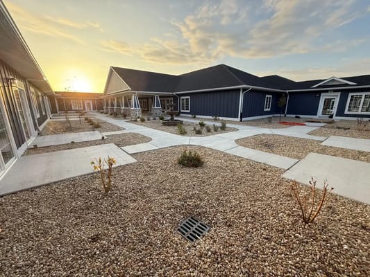 Sunset over the landscaped courtyard with stone paths at Hampton Manor of Chesapeake.