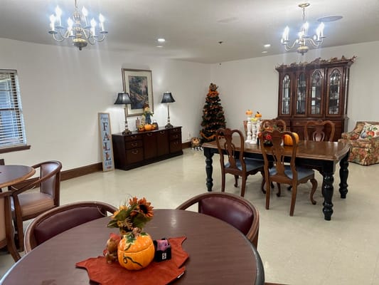 Dining room decorated for fall with pumpkins and a Christmas tree