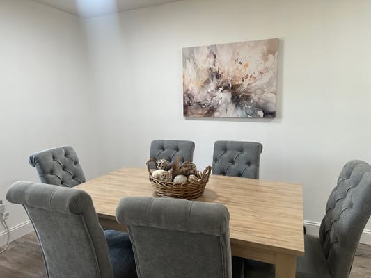 A cozy dining area featuring a table with decorative items and plush chairs.