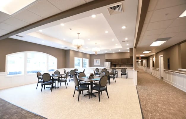 Dining area with tables and chairs in a senior living facility
