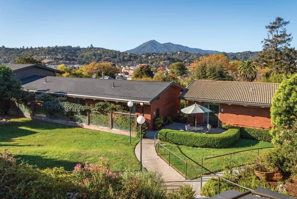 Outdoor view of the facility with gardens and mountain backdrop