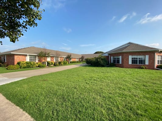 Well-maintained exterior of The Brentwood Senior Living facility on a sunny day