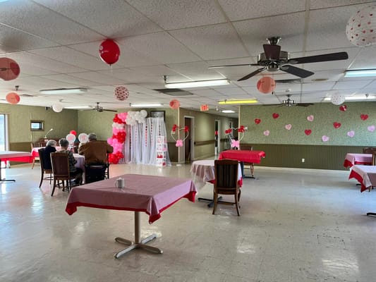 Decorated dining area for Valentine's Day celebration with balloons and heart decorations.