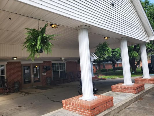 Entrance with hanging ferns and brick columns
