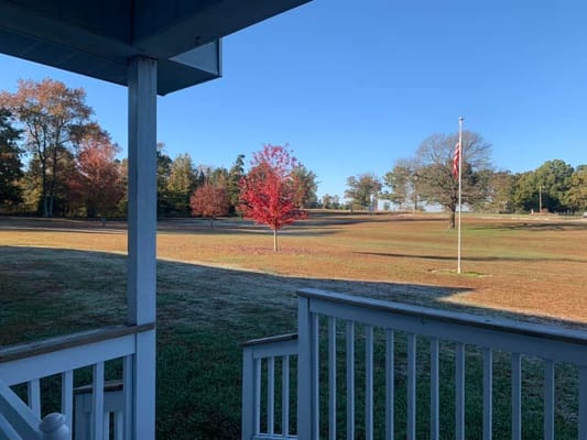 Vibrant fall foliage with a clear sky viewed from the porch