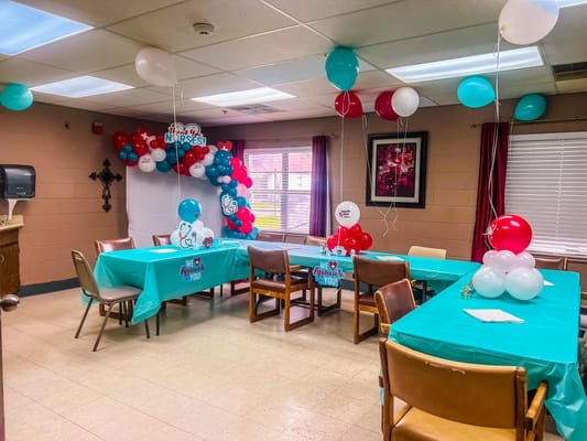 Decorated dining room with balloons and tables set for an event