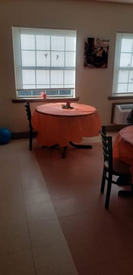 Cozy dining area with orange tablecloths and a decorative centerpiece
