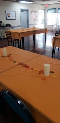 Tables with orange tablecloths and decorative leaves in a dining area