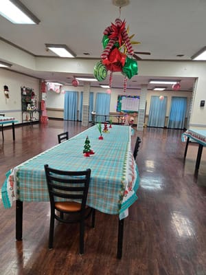 Dining hall with holiday decorations and table settings.