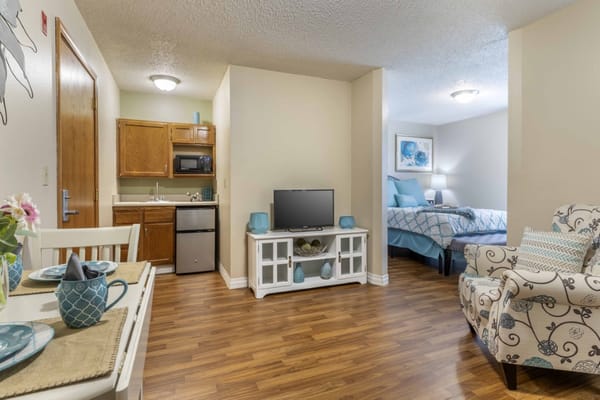 Bright interior of a resident room with kitchenette and seating area