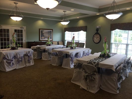 Decorated event space with tables and floral arrangements.