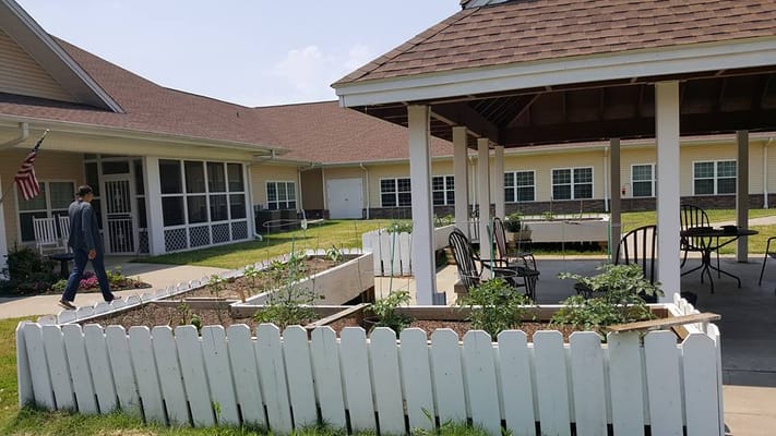 Outdoor garden area with raised beds and seating at St. Francis Assisted Living