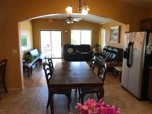 Spacious living room with dining table and black sofas