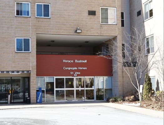 Entrance to Horace Bushnell Congregate Homes featuring a brown sign.