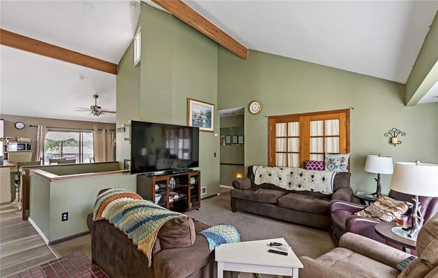 A comfortable living room with brown couches and a TV