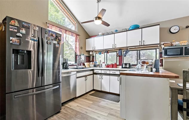 Kitchen with stainless steel appliances and a view of the outdoors.