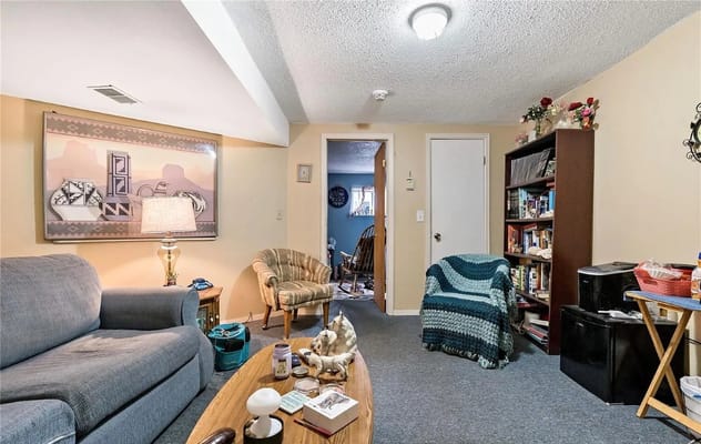 Cozy living room featuring a blue couch and a bookshelf.