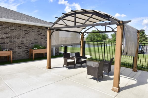 Outdoor shaded seating area with chairs and tables