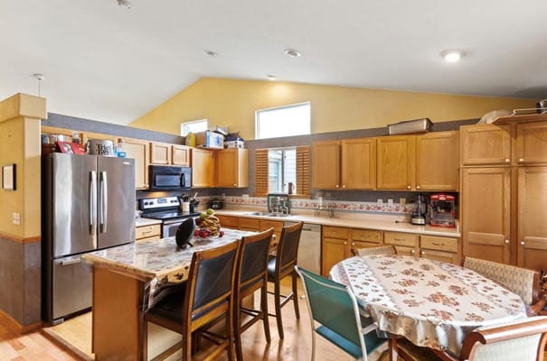 A well-equipped kitchen with wooden cabinets and a dining table