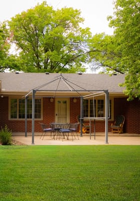 Outdoor patio area with seating and a view of the home