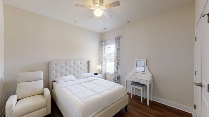 A cozy bedroom with a bed and a chair