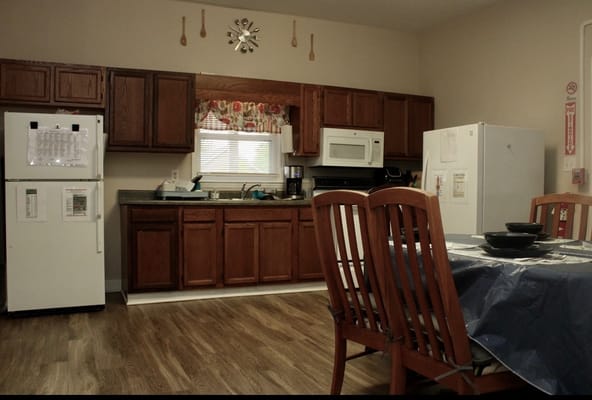 A kitchen area with wooden cabinets and table setting