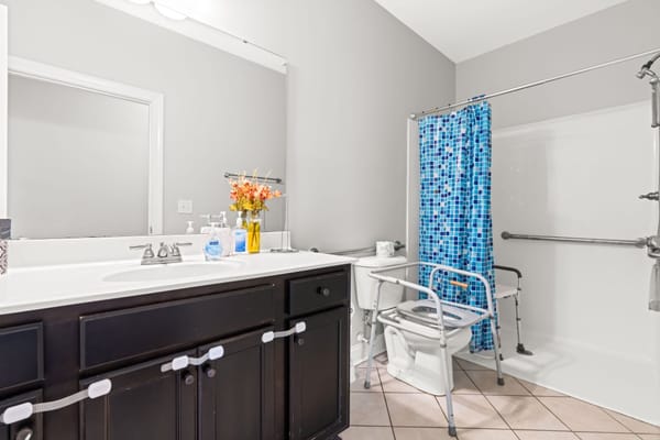 Accessible bathroom with grab bars and shower chair