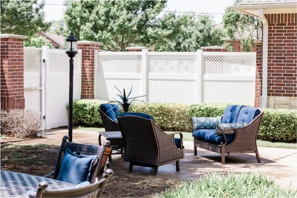 Outdoor seating area with chairs and greenery