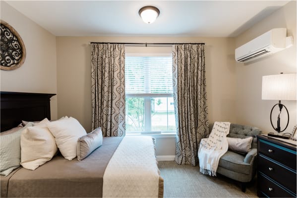 Comfortable bedroom with a bed, window, and seating area.