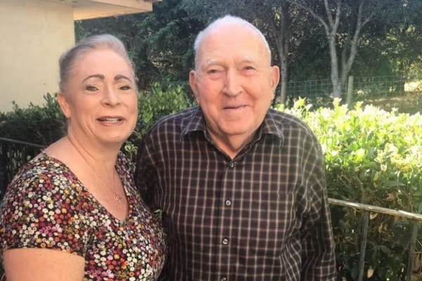 Resident and staff member smiling outdoors