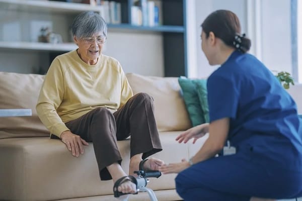Patient receiving assistance from a caregiver in a living room