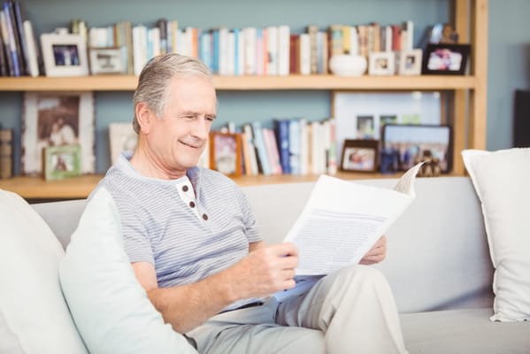 Senior man reading a document on a couch