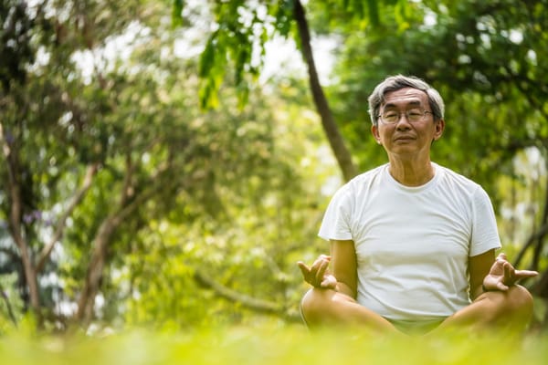 Senior man meditating outdoors in a serene garden