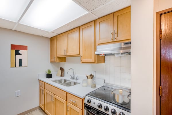A well-lit kitchen area with wooden cabinetry