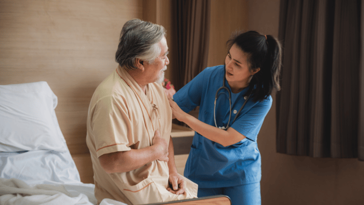 A caregiver assisting a resident in a bright room