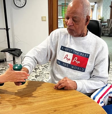 Resident engaging in an activity with staff assistance