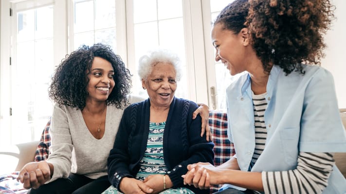 Residents and staff smiling together in a cozy common area
