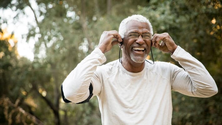 Smiling senior man enjoying outdoors with headphones