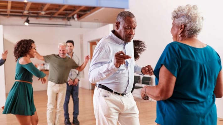 Residents dancing happily in a bright activity room