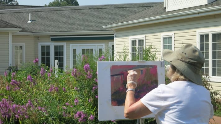 Resident painting in the garden with flowers