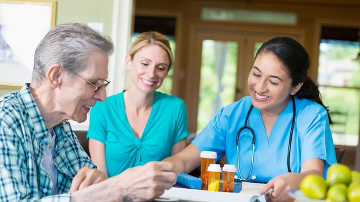 A caregiver interacting with a senior resident at a table