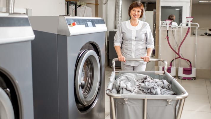 Staff member doing laundry in a facility laundry room