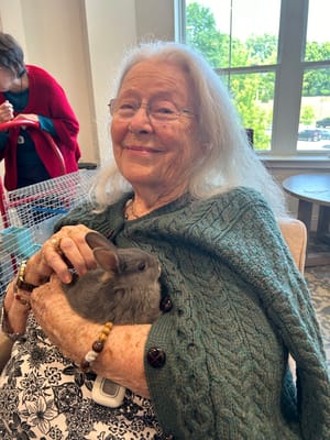 Resident holding a rabbit in a cozy interior setting
