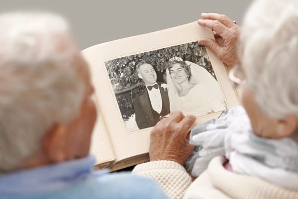 Elderly couple viewing a wedding photo in an album