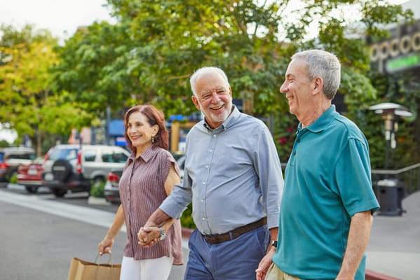 Three residents walking together outside in a community