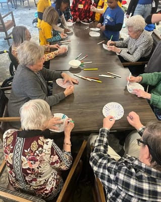 Residents engaged in a coloring activity around a table