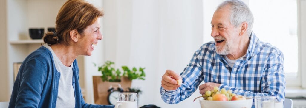 Two seniors enjoying a meal together in a bright setting