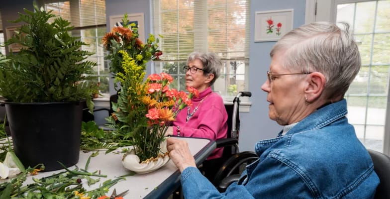 Residents engaging in a floral arrangement activity indoors